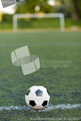 Image of soccer ball on football field marking line