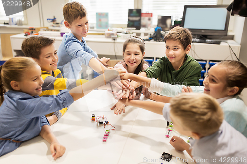 Image of happy children holding hands at robotics school