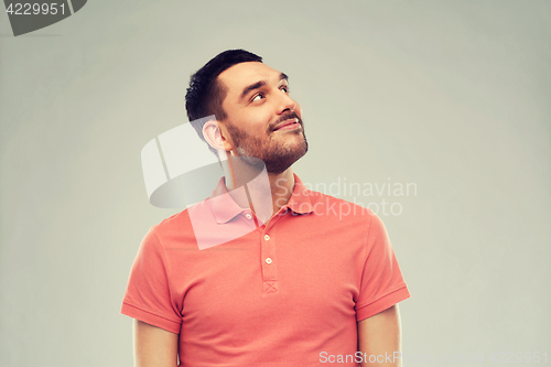 Image of smiling man looking up over gray background