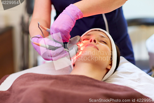 Image of young woman having face microdermabrasion at spa