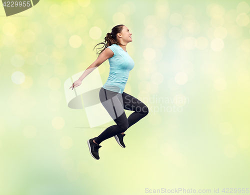 Image of happy smiling sporty young woman jumping in air