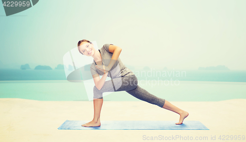 Image of woman making yoga low angle lunge pose on mat