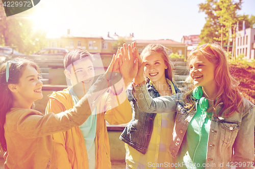 Image of happy students or friends making high five