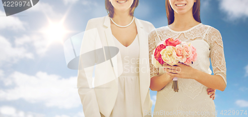 Image of close up of happy lesbian couple with flowers