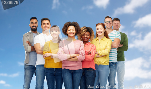 Image of international group of happy people over blue sky