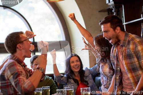 Image of football fans or friends with beer at sport bar