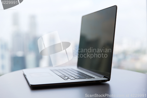 Image of laptop computer with black screen on office table