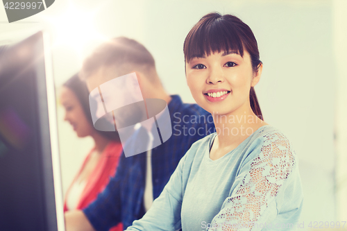 Image of happy creative team or students working at office