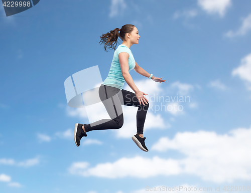 Image of happy smiling sporty young woman jumping in air