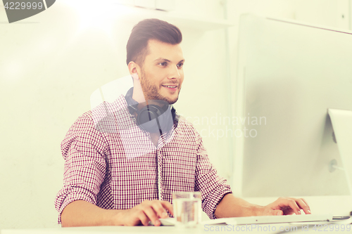 Image of creative man with headphones and computer