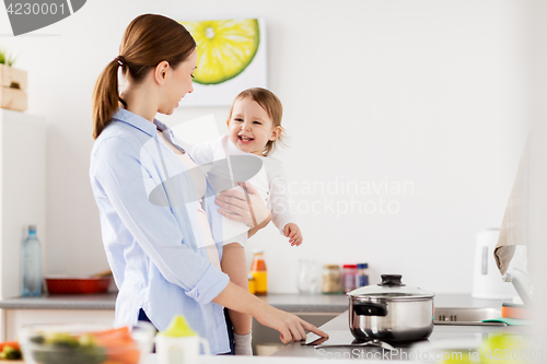 Image of happy mother and baby cooking at home kitchen