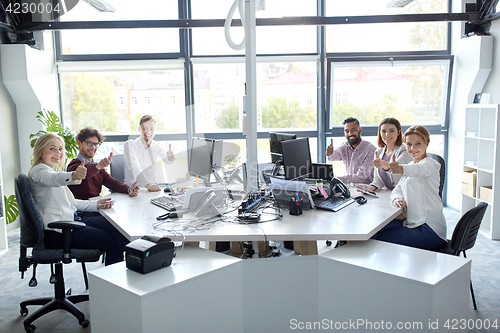 Image of business team showing thumbs up at office