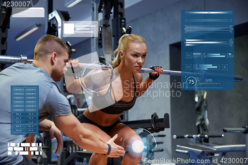 Image of man and woman with bar flexing muscles in gym