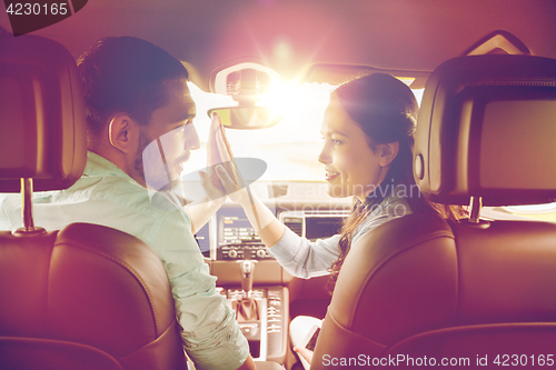 Image of happy man and woman driving in car