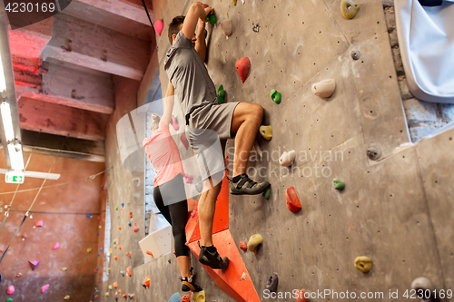 Image of man and woman exercising at indoor climbing gym