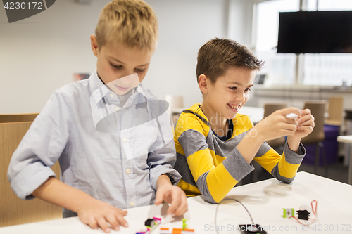 Image of happy children building robots at robotics school