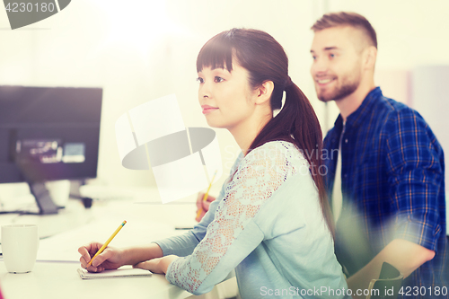 Image of happy creative team or students working at office