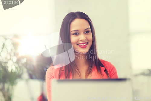 Image of happy african woman with laptop computer at office