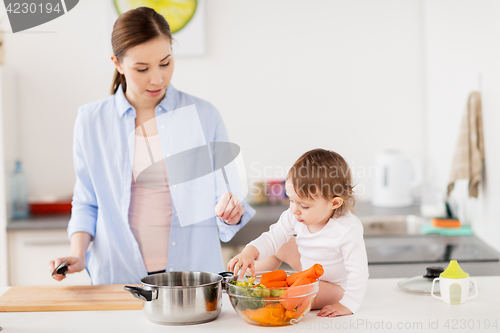 Image of happy mother and baby cooking food at home kitchen
