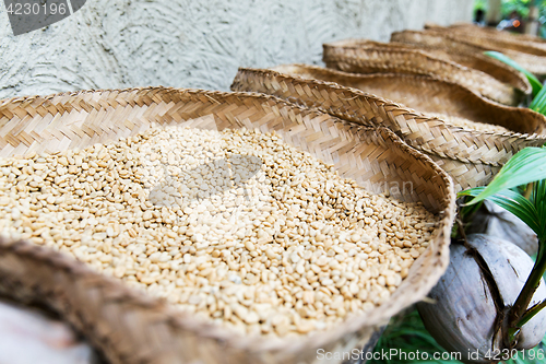 Image of unroasted coffee beans in baskets at street market