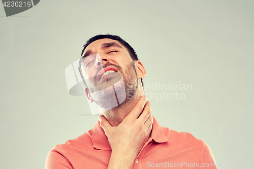 Image of man touching neck and suffering from throat pain