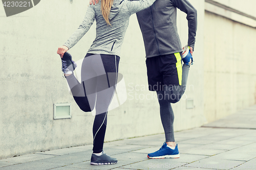 Image of close up of couple stretching legs outdoors