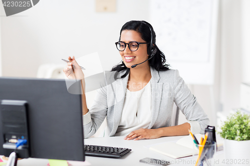 Image of businesswoman with headset and computer at office