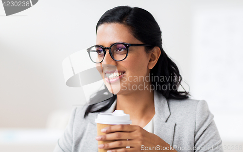 Image of businesswoman with coffee in paper cup at office