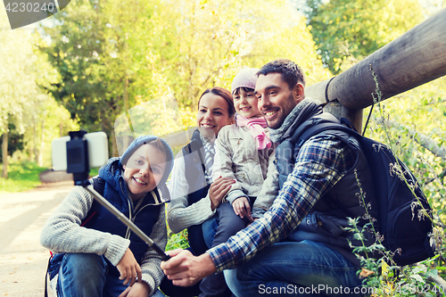 Image of family with backpacks taking selfie and hiking