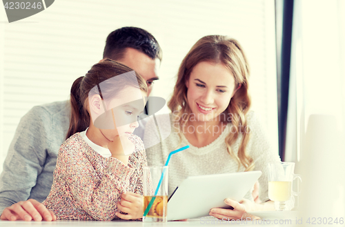 Image of happy family with tablet pc at restaurant