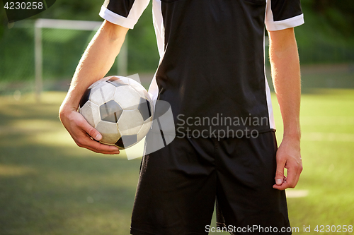 Image of soccer player with ball on football field