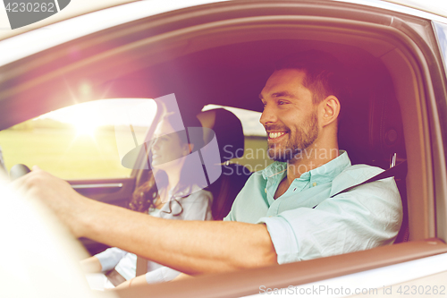 Image of happy man and woman driving in car