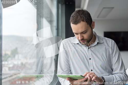 Image of Businessman Using Tablet In Office Building by window