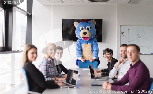 Image of boss dresed as bear having fun with business people in trendy of