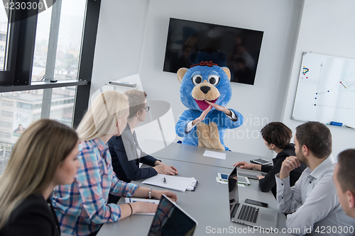 Image of boss dresed as bear having fun with business people in trendy of