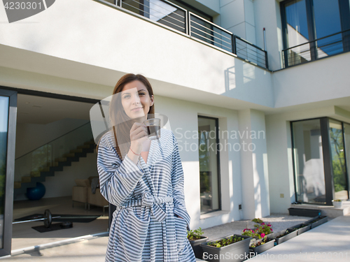 Image of woman in a bathrobe enjoying morning coffee