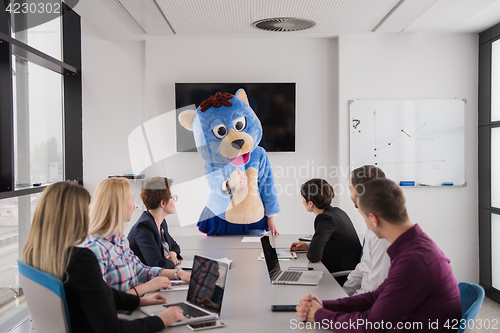 Image of boss dresed as bear having fun with business people in trendy of