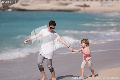 Image of mother and daughter running on the beach