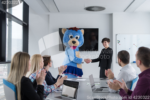 Image of boss dresed as bear having fun with business people in trendy of