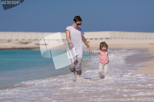 Image of mother and daughter running on the beach