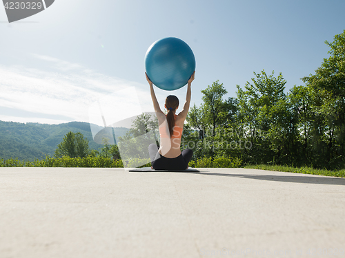 Image of woman doing exercise with pilates ball