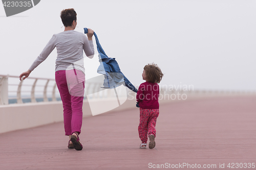 Image of mother and cute little girl on the promenade by the sea