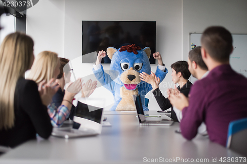 Image of boss dresed as bear having fun with business people in trendy of