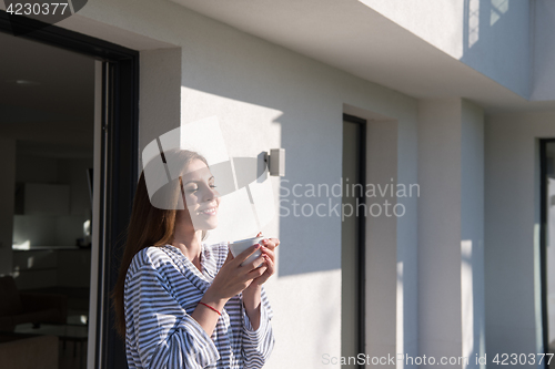 Image of woman in a bathrobe enjoying morning coffee