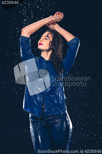 Image of Young beautiful woman under splash of rain