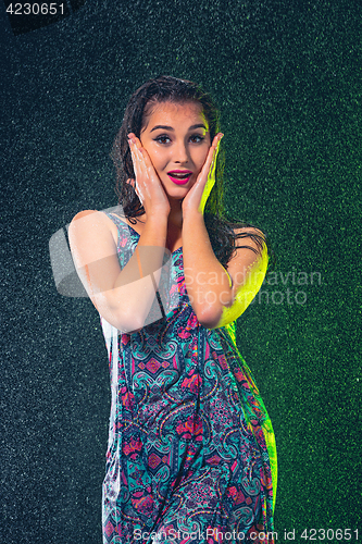 Image of Young beautiful woman under splash of rain