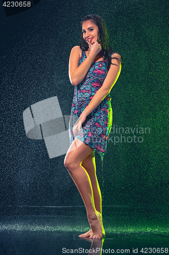 Image of Young beautiful woman under splash of rain