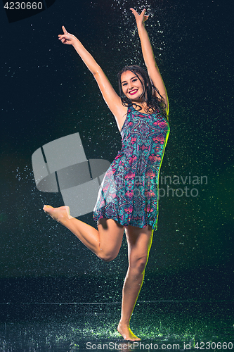 Image of Young beautiful woman under splash of rain