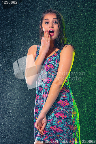 Image of Young beautiful woman under splash of rain