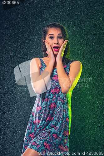 Image of Young beautiful woman under splash of rain